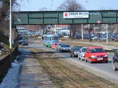 A 7221-es kiálló kocsit akadályozzák a vasúti átjáró előtt összegyűlt autók a kocsiszín előtt. Háttérben az autóbuszgarázs és a kocsiszín., Kocsiszín előtt, Eszék (forrás: Gábor Marcell)